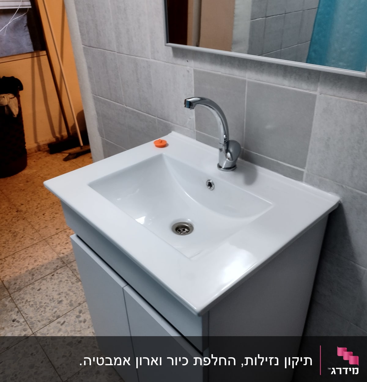 כיור לבן עם ברז כרום בחדר אמבטיה